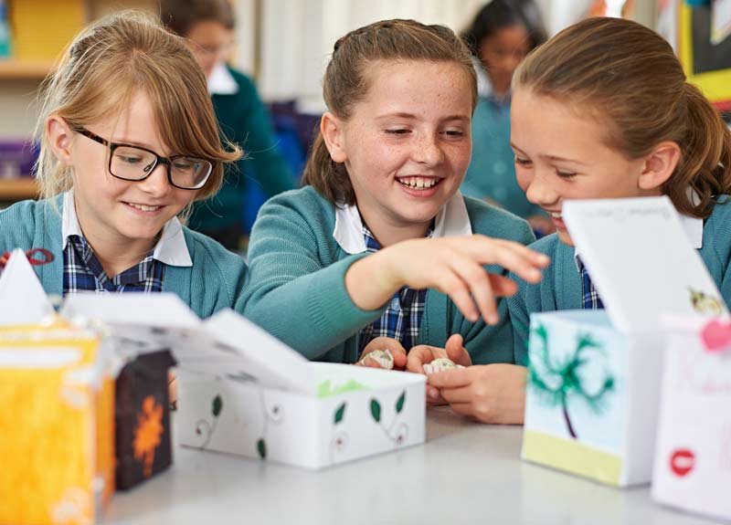 Three girls smile and have fun in class