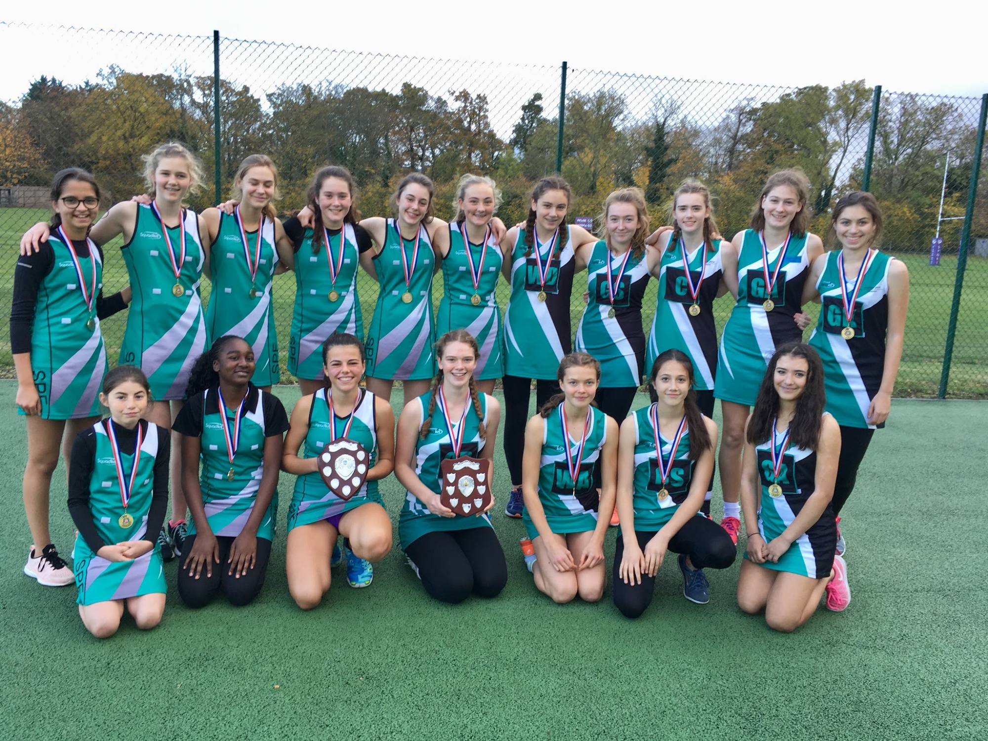 U14 and U16 netball team pose with winners medals and trophies