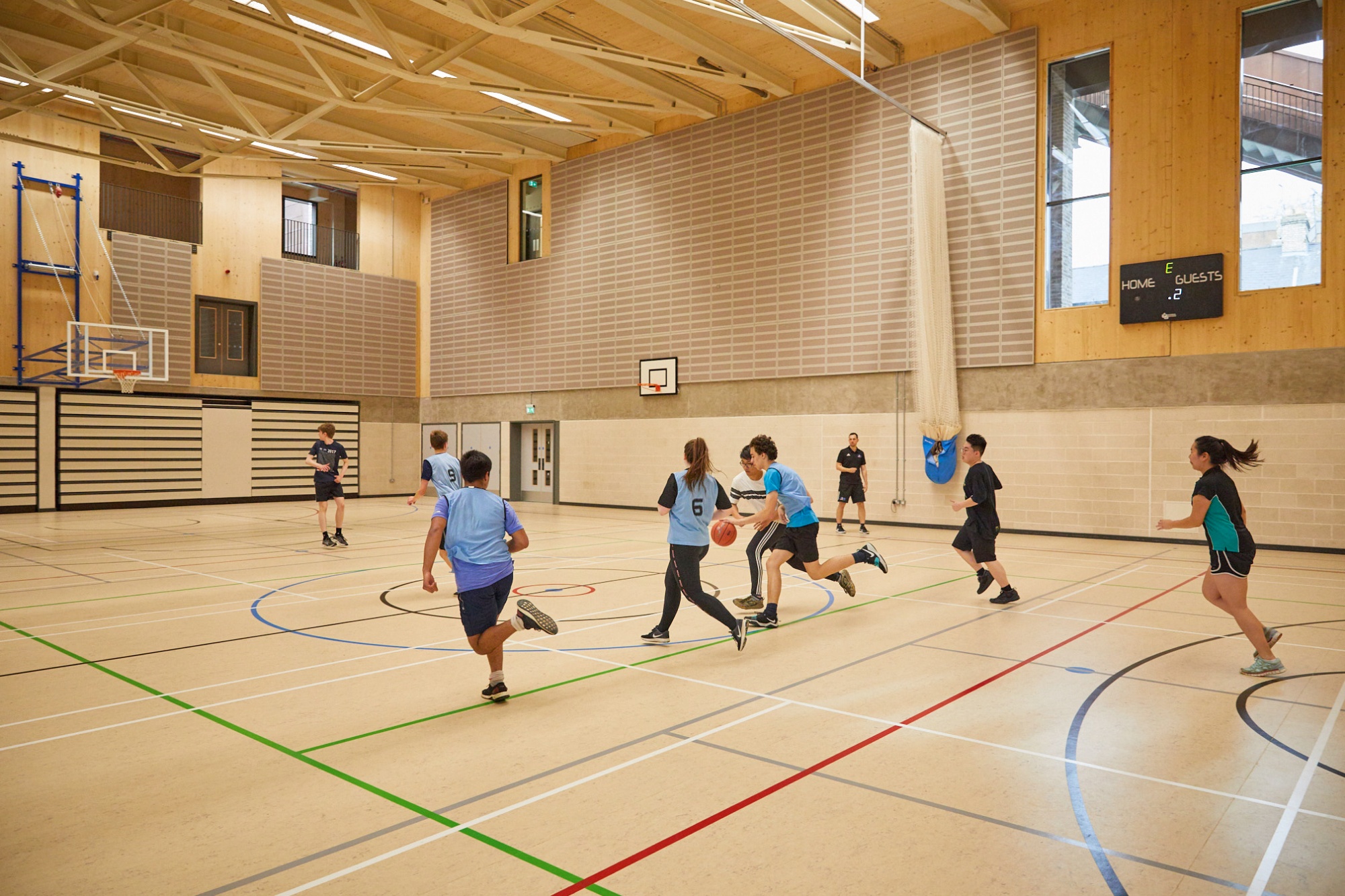 Students playing basketball in the sports hall