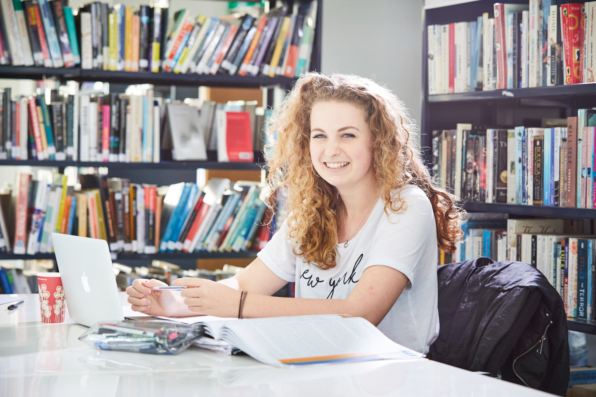 Image of student studying in library to illustrate link to 'Newsletters' page
