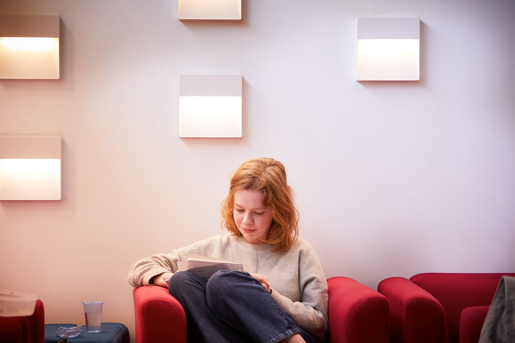 Sixth form student reading on sofa