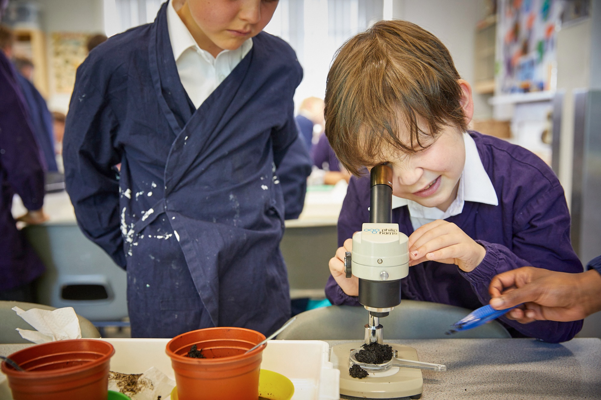 Image of student looking at microscope to illustrate link to 'Calendar and Term Dates' page