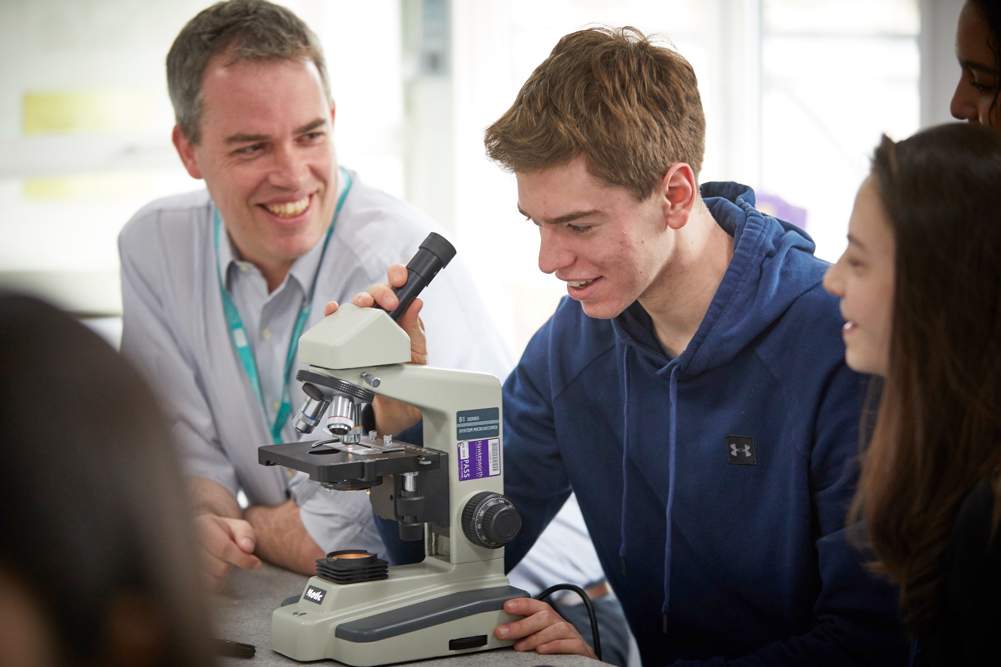Student in class looking at microscope