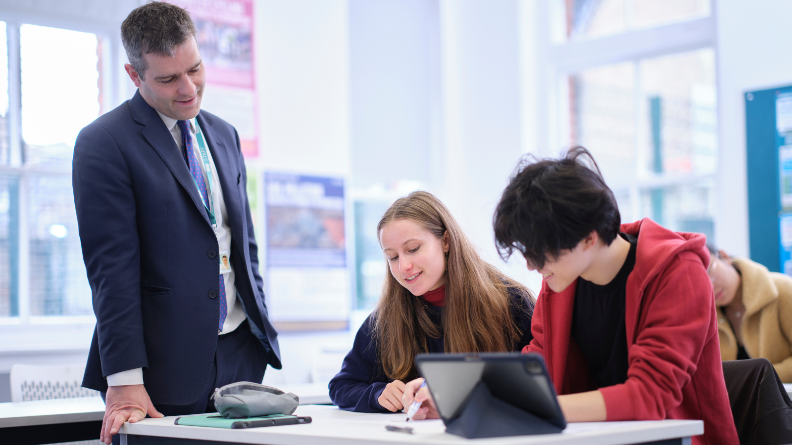 Image of students working in class with a teacher to illustrate link to 'Guidance and Support' page
