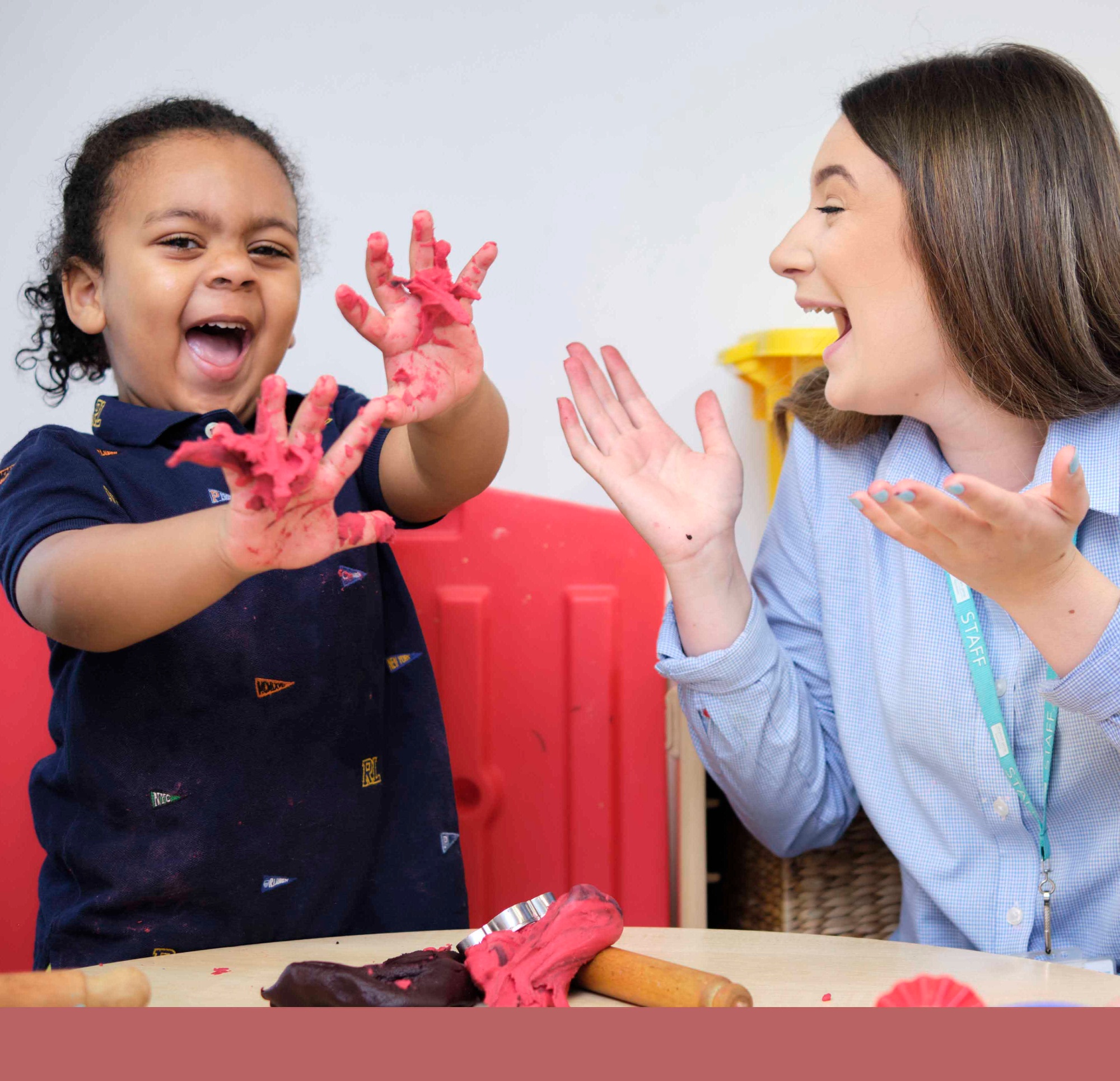 Image of pupil and teacher painting to illustrate link to 'Nursery and Early Years' page