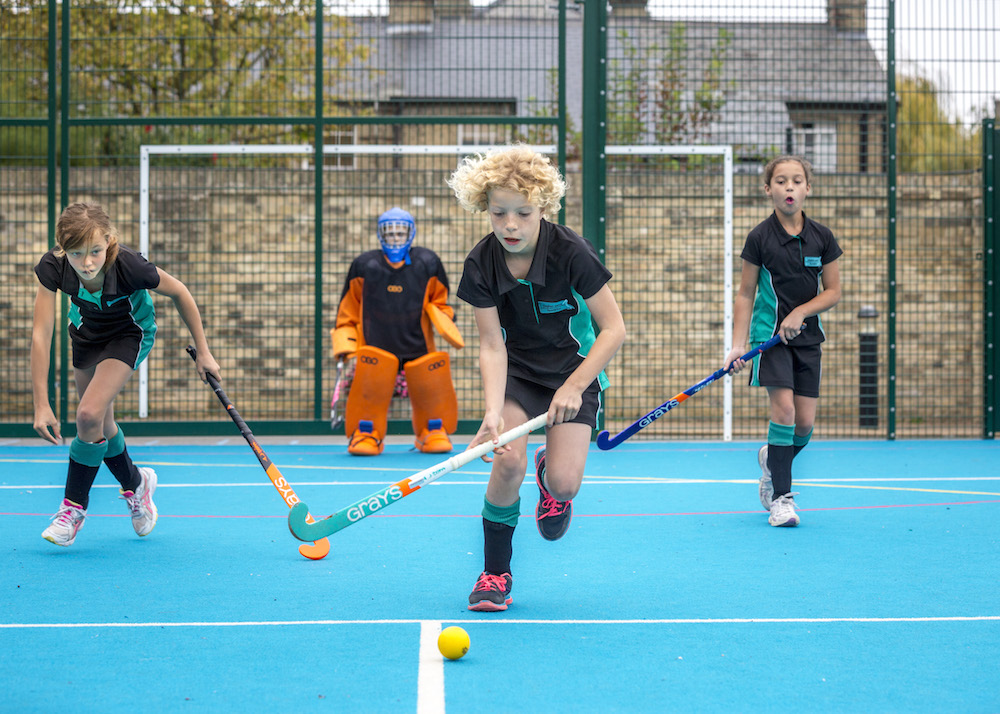 Pupils at junior school playing hockey