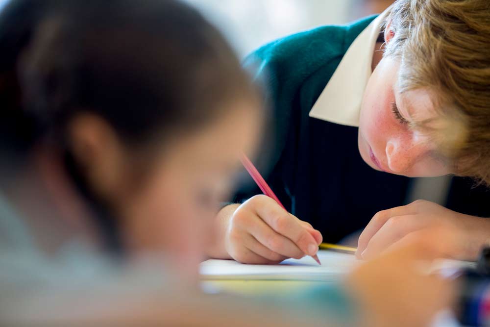 Pupil writing in classroom