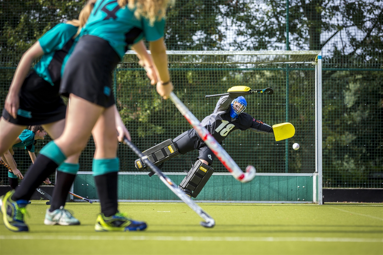 Image of students playing hockey to illustrate link to 'Sports fixtures' page
