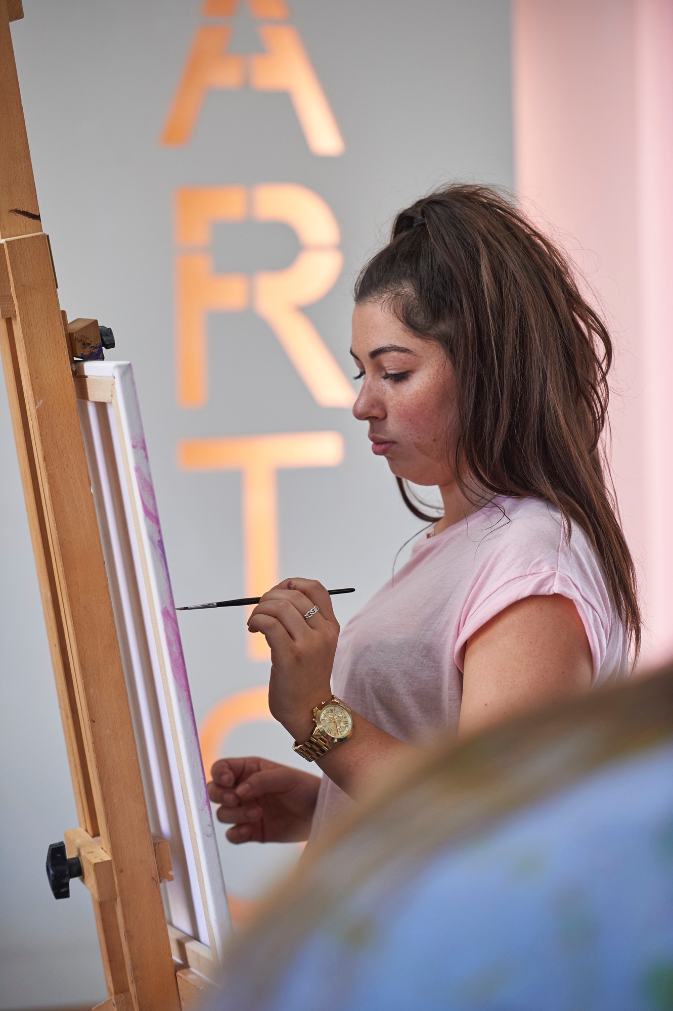 Girl in sixth form art class painting