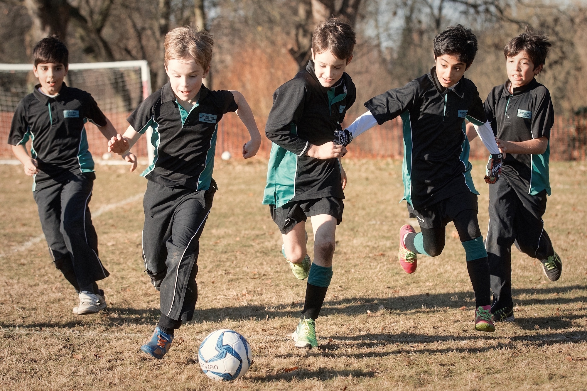 Pupils playing football to illustrate link to 'Stephen Perse Fixtures and Teams' page