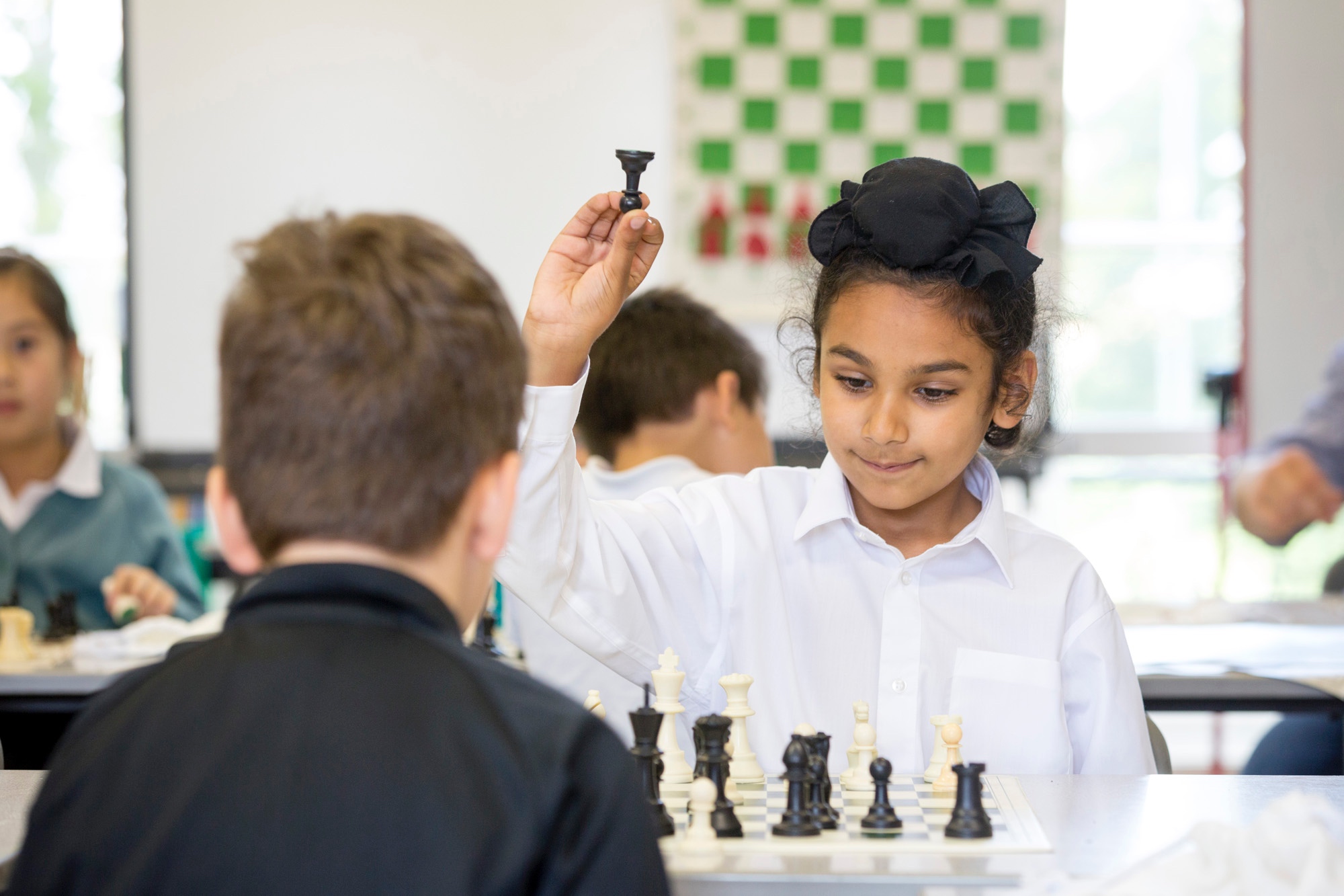 Image of pupils playing chess to illustrate link to 'Clubs and Activities' page