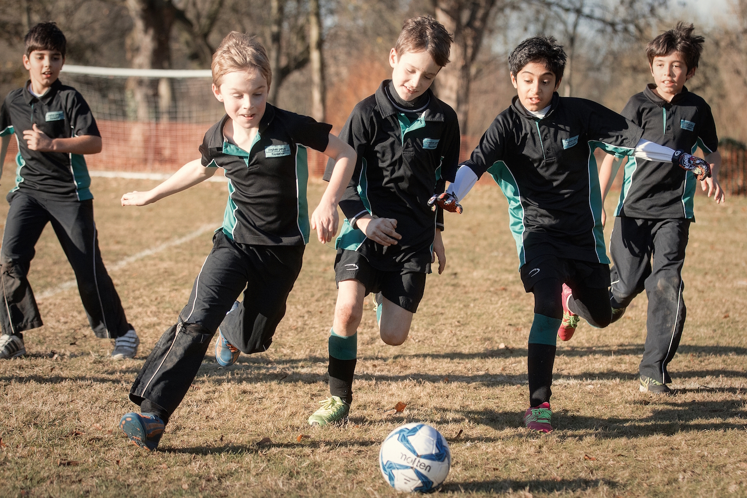 Image of pupils playing football to illustrate link to 'Sports fixtures' page